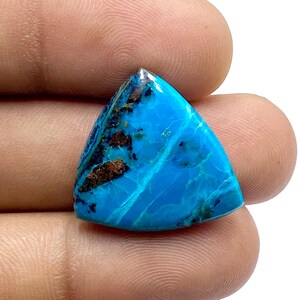 Könnte beinhalten: Ein dreieckiger Cabochon aus Türkis mit blauer und grüner Farbe und braunen Einschlüssen.