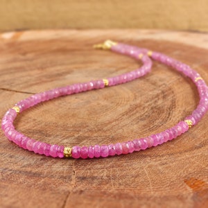 Peut inclure: Un collier de pierres précieuses roses avec des accents dorés. Le collier est composé de petites perles facettées et est enfilé sur une chaîne délicate.