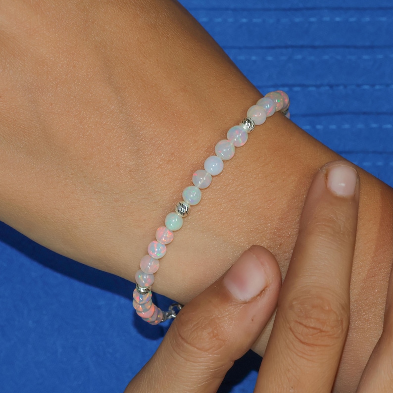 May include: A bracelet made of white and pink opal beads with silver accents.