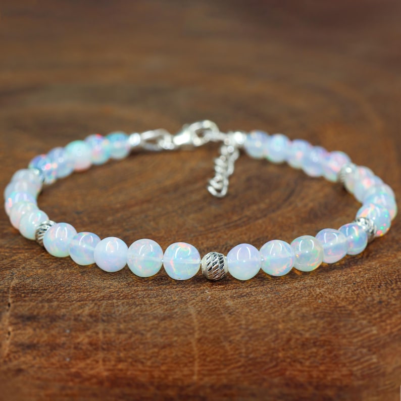 May include: A delicate silver bracelet with a chain closure and white opal beads.