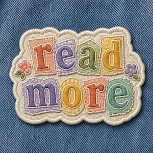 May include: Embroidered patch with the words "read more" in colorful, textured letters. The patch has a scalloped edge and small flower accents. The letters are in shades of orange, purple, green, and yellow.