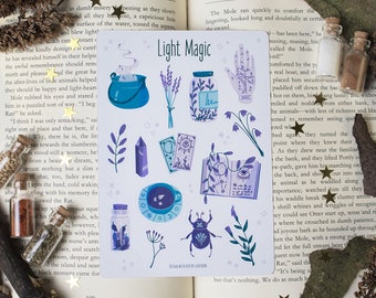 May include: A set of 10 light magic stickers featuring illustrations of a cauldron, a crystal, a book, a hand, a beetle, a jar, a cup, a flower, and a compass. The stickers are on a white background with a light purple and teal color scheme. The text "Light Magic" is printed at the top of the sheet.