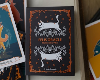 May include: A black card with an orange border features a white cat with a black tail and black ears. The card has the text "Felis Oracle - The Pawsitive Vibes - By Sarah Bourquin" in orange text.