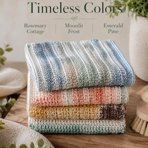 May include: A stack of four rectangular crocheted cloths with textured horizontal stripes. The top cloth features blue and white tones, the second has peach and white, the third is yellow and brown, and the bottom is green and white. Text reads: THREE BEAUTIFUL Timeless Colors Rosemary Cottage | Moonlit Frost | Emerald Pine.