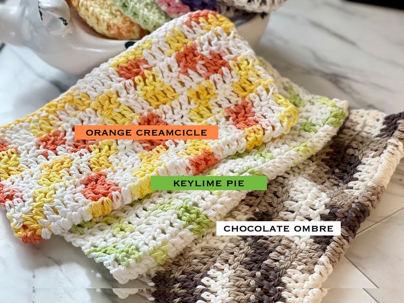 May include: Three rectangular crocheted washcloths with textured patterns. The top cloth is white, yellow, and orange with the text ORANGE CREAMCICLE. The middle cloth is white and light green with the text KEYLIME PIE. The bottom cloth is white and brown with the text CHOCOLATE OMBRE.