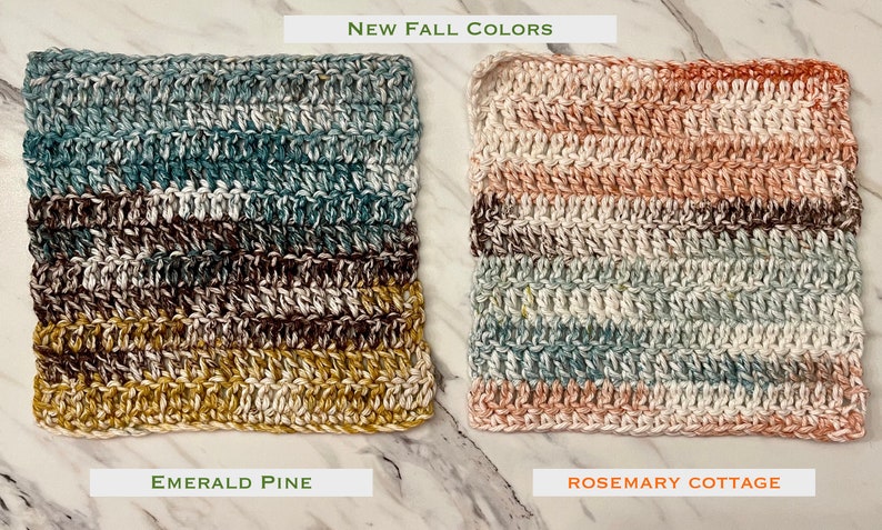 May include: Two square crochet washcloths with horizontal stripes. The left cloth, labeled Emerald Pine, features shades of blue, brown, and mustard yellow. The right cloth, labeled Rosemary Cottage, features shades of cream, peach, and sage green.