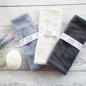 May include: Three face cloths in different colors: light blue, white, and gray. Each cloth has a white label that says "Ece Us Face Cloth".