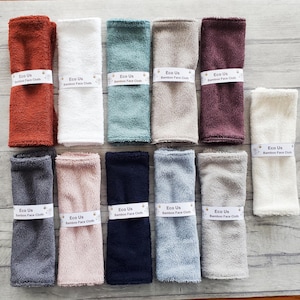 May include: Ten bamboo face cloths in various colors, including brown, white, green, beige, and gray. Each cloth has the text "Eco Us Bamboo Face Cloth" printed on it.