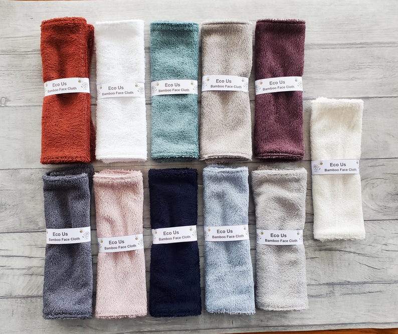 May include: Ten bamboo face cloths in various colors, including brown, white, green, beige, and gray. Each cloth has the text "Eco Us Bamboo Face Cloth" printed on it.