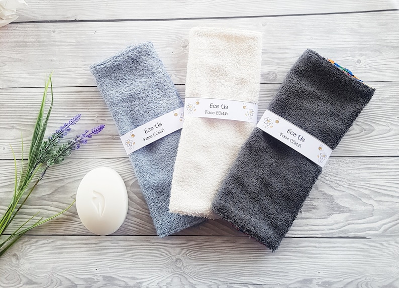 May include: Three face cloths in different colors: light blue, white, and gray. Each cloth has a white label that says "Ece Us Face Cloth".