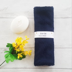 May include: A dark blue face cloth with a white label that reads "Eco Us Face Cloth".