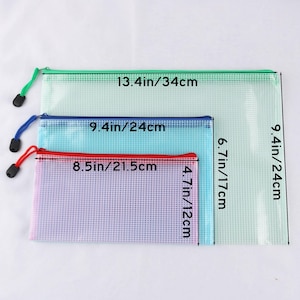 May include: Three zippered mesh pouches in varying sizes. The largest is light green, 13.4 inches (34 cm) wide and 9.4 inches (24 cm) tall. The medium pouch is blue, 9.4 inches (24 cm) wide and 6.7 inches (17 cm) tall. The smallest is pink, 8.5 inches (21.5 cm) wide and 4.7 inches (12 cm) tall.
