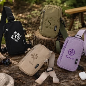 May include: Four crossbody sling bags in black, olive green, beige, and light purple. Each bag features a front zipper pocket, an adjustable strap, and a unique graphic print. The black bag has a letter D, the green has a letter S and SILVIA, the beige has a palm tree and Winnie, and the purple has a compass and Michael.