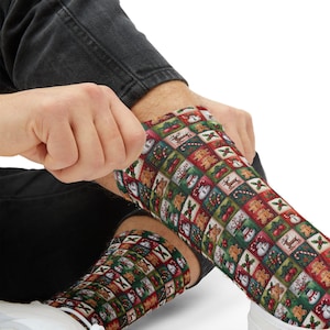 Peut inclure: Chaussettes de Noël avec un motif répétitif de carrés festifs. Chaque carré présente des icônes de vacances comme des bonhommes en pain d'épices, des rennes, des bonhommes de neige et des cannes en bonbon. Les chaussettes sont principalement rouges, vertes et blanches.