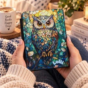 Op de afbeelding: Een rechthoekige e-reader hoes met een kleurrijke illustratie in glas-in-loodstijl van een uil op een tak. Het ontwerp bevat tinten blauw, turquoise, geel en oranje. Het woord Lolli staat in witte letters in de onderste hoek gedrukt.