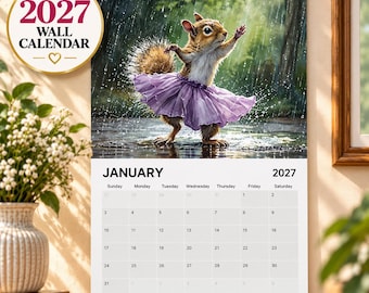May include: A 2027 wall calendar featuring a squirrel wearing a purple tutu dancing in the rain. The top section displays the squirrel illustration, while the bottom section shows the January 2027 calendar grid with days of the week listed.