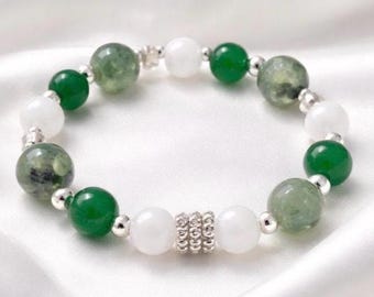 Puede incluir: Una pulsera de cuentas con cuentas redondas verdes y blancas alternadas. Las cuentas verdes varían en tono desde verde claro translúcido hasta verde oscuro sólido. Las cuentas blancas son opacas y lisas. Pequeños espaciadores plateados separan.
