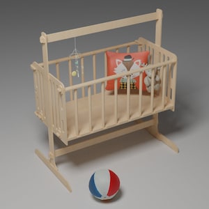 Puede incluir: Una cuna de beb&eacute; de madera de color claro con una almohada decorativa con un dise&ntilde;o de zorro, un peque&ntilde;o oso de peluche y un m&oacute;vil colgante. Una pelota roja, blanca y azul descansa en el suelo frente a la cuna.