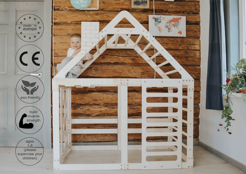 May include: White wooden playhouse with a climbing wall, ladder, and a small chimney. The playhouse is designed for children aged 1-8 and is made in Europe. The playhouse is eco-friendly and helps build muscle strength.