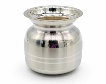 May include: A small, polished silver-colored metal pot with a wide, flared rim and a rounded body. The exterior surface features a smooth, reflective finish with two thin, horizontal engraved lines encircling the lower section of the vessel.