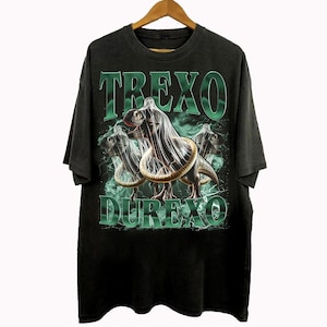 K&ouml;nnte beinhalten: Schwarzes T-Shirt mit einem Grafikdesign, das drei Dinosaurier mit Kondomen zeigt, mit den Worten "TREXO DUREXO" in Gr&uuml;n. Das Design umfasst gr&uuml;ne Blitze und einen rauchigen Hintergrund.