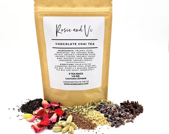 May include: A brown paper bag with a white label that reads "Rosie and Vi Chocolate Chai Tea". The label lists the ingredients and directions for brewing the tea. The bag is surrounded by loose tea ingredients, including rose petals, ginger, cinnamon, cacao nibs, cloves, cardamom, and stevia.