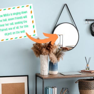 May include: A light blue wall with a round black mirror hanging on it. A decorative sign with the text "Snow White is singing down the hall, seven friends will hear her call, seeking the fairest one of all, for this object on the wall." is hanging on the wall. A brown wooden table with a laptop, a vase with dried flowers, and a basket is in front of the wall.
