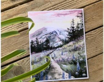 Puede incluir: Pintura acuarela de una cordillera con un camino que conduce a través de un campo de flores silvestres moradas. El cielo es de un rosa y amarillo suave.