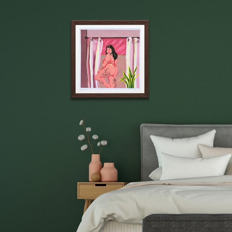K&ouml;nnte beinhalten: Eine gerahmte Illustration einer Person, die in einem Badezimmer mit einer rosafarbenen gekachelten Wand, wei&szlig;en Vorh&auml;ngen und einer gr&uuml;nen Pflanze steht. Die Person tr&auml;gt einen rosafarbenen Badeanzug und hat T&auml;towierungen auf den Beinen.