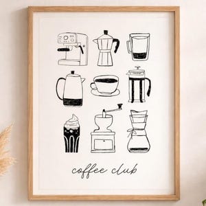 May include: A framed print featuring black and white illustrations of coffee-making equipment, including an espresso machine, a moka pot, a French press, and a coffee grinder. The words "coffee club" are written in cursive at the bottom.