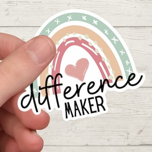 May include: A rainbow sticker with a heart and the text "difference maker" in black lettering.