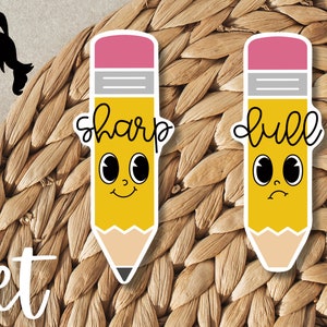 May include: Set of two yellow pencil stickers with black outlines. One pencil has the word "sharp" written above it and a happy face. The other pencil has the word "dull" written above it and a sad face.