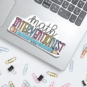 May include: A colorful sticker with the text "math interventionist" and a pencil drawn in rainbow colors. The sticker is on a silver laptop.