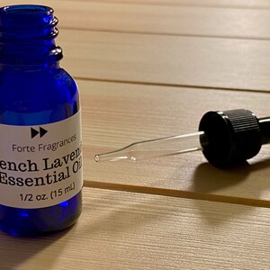Op de afbeelding: Een blauwe glazen fles met een druppelaar, met het label "Forte Fragrances French Lavender Essential Oil 1/2 oz. (15 ml)"