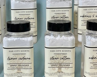 May include: Eight white plastic bottles with black lids containing carpet freshener. The bottles are labeled with the brand name "Oak City Scents" and the scent names "Lavender", "Lemon Verbena", "Clean Cotton", and "Oakmoss & Amber".