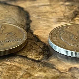 May include: Two vintage Greek coins. One coin features an owl and the text "2 DRAXMAI". The other coin displays an eagle and the text "&Epsilon;&Lambda;&Lambda;&Eta;&Nu;&Iota;&Kappa;&Eta; &Delta;&Eta;&Mu;&Omicron;&Kappa;&Rho;&Alpha;&Tau;&Iota;&Alpha; 1974". Both coins are bronze-colored and have a ridged edge.