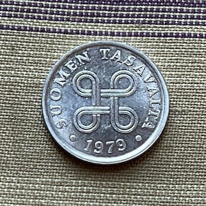 May include: A silver Finnish coin with the text "Suomen Tasavalta" and the year "1979" on it.