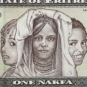 May include: A brown and white banknote featuring three women's faces. The center woman is wearing a head covering and a beaded necklace. The text "ONE NAKFA" is printed at the bottom of the banknote.