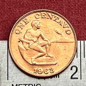 May include: A copper-colored coin with the words "ONE CENTAVO" and the year "1963" inscribed on it. The coin features a depiction of a man working with a hammer and anvil.