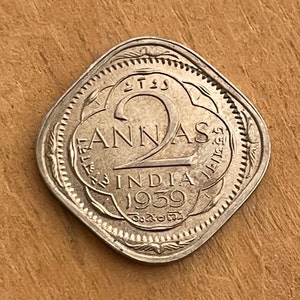 May include: A silver Indian coin with the inscription "2 Annas India 1959" and a large numeral "2" in the center.