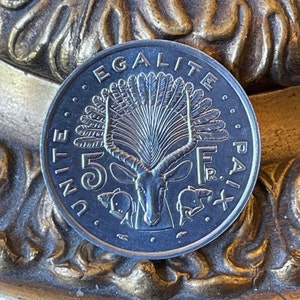 Peut inclure: Une pièce d'argent représentant une antilope et un arbre avec une couronne en éventail. La pièce porte les inscriptions "UNITE", "EGALITE", "FR" et "PAIX" sur le bord. Le chiffre "5" est également visible sur la pièce.