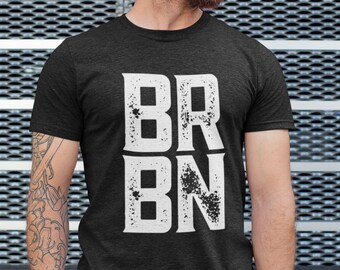 Puede incluir: Una camiseta gris oscuro con un estampado gráfico blanco que dice "BRBN".