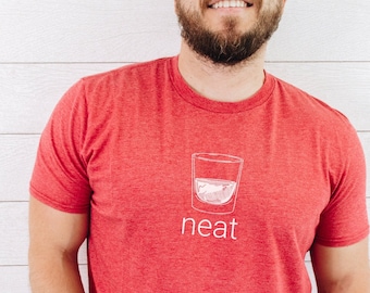 Puede incluir: Camiseta roja con un gráfico blanco de un vaso de alcohol y la palabra "neat" impresa en la parte delantera.