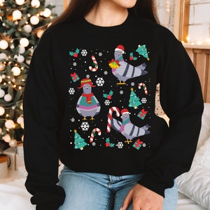 May include: Black Christmas jumper featuring a festive design of pigeons wearing Santa hats, candy canes and Christmas trees.