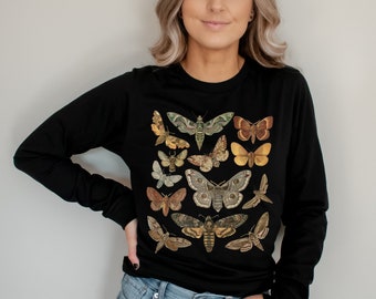 May include: Black long-sleeved shirt with a print of various butterflies in shades of brown, yellow, and green.