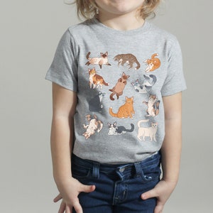 May include: A gray t-shirt with a print of various cats in different poses. The cats are in shades of gray, white, orange, and brown.