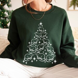 May include: A dark green sweatshirt with a white design of a Christmas tree made of rats. The rats are arranged in a pyramid shape with a star at the top.