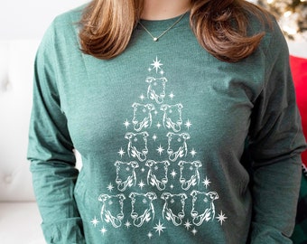 May include: A green long-sleeved shirt with a white Christmas tree design featuring a pattern of greyhound dog faces.
