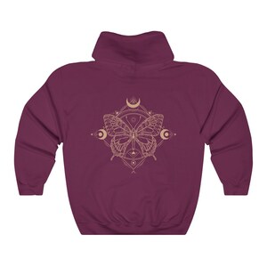 May include: Burgundy hooded sweatshirt with a graphic of a butterfly inside a geometric design with moons and stars.