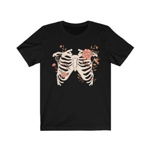 May include: Black t-shirt with a graphic of a ribcage surrounded by flowers and a hummingbird.